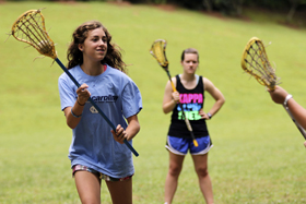 girls enjoy field hockey instruction at summer camp
