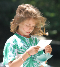 Camp Illahee camper reading a letter from her parents