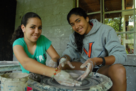 camper throws clay pot on wheel at Camp Illahee summer camp for girls
