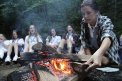 summer camp girl building campfire at Camp Illahee