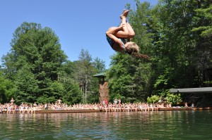 Illahee girls camp camper does a front flip off the diving board.