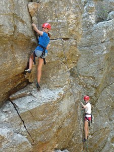 Girls camp campers rock climbing.