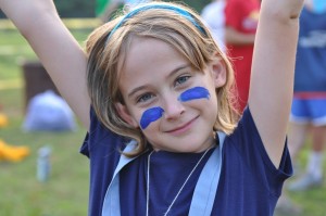 girls camp camper holds hands up in victory during capture the flag