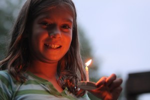 Girls camper floats wish boat at Camp Illahee Summer Camp for Girls