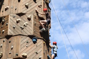 girls climb on climbing tower at camp