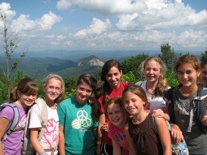 camp girls on a hike with looking glass rock in the background