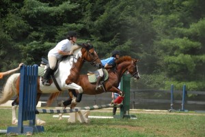 two riders jump horses at same time at illahee girls camp
