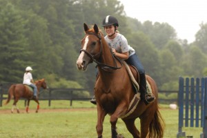 girls jumps horse at summer camp