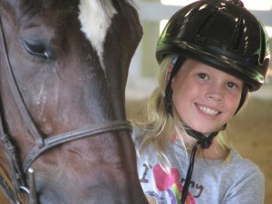A girl poses with favorite horse at camp