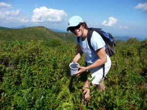 Laurie Strayhorn shows quart container full of blueberries.