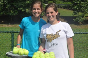 Two campers pose with racquets filled with tennis balls