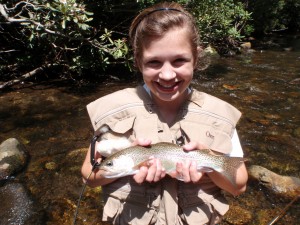 A summer camp girl holds recently caught trout.