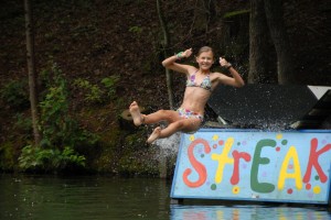 A summer camp girl slides down the Streak water slide at Camp Illahee.