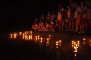 Summer camp girls at Illahee float lighted wishboats on the lake.