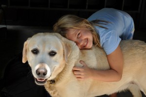 A camper hugs Newton the camp dog.