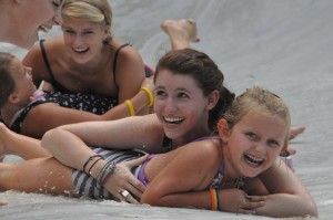 Two counselors and a summer camp girl slide down the Slip n Slide at Camp Illahee Summer Camp for Girls.