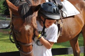 A camper and a horse look like they are sharing a laugh at camp.