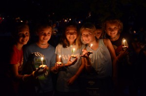 4 girls hold wish boat candles prior to floating them on the lake at camp.