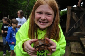 A Camp Illahee camper poses with a turtle.