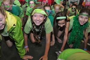 Summer Campers dressed in green crawl toward the camera.