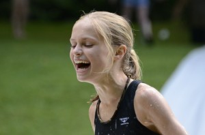 A girl laughs after sliding down the slip n slide