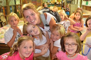 Summer camp girls in cabin one pose with their counselor in Arts and Crafts.