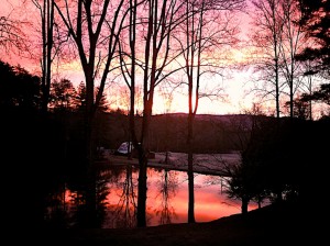 A pink and red sunrise frames the barn and pastures at Camp Illahee/