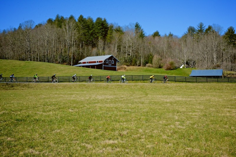 A group of road bikers ride by Hannah Ford Farm.