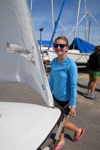 A camper wheels her 420 class sailboat to its launch.