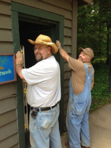 Carpenters check a door for square.