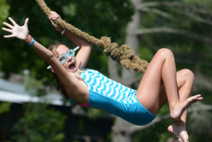 Girl on a rope swing over lake