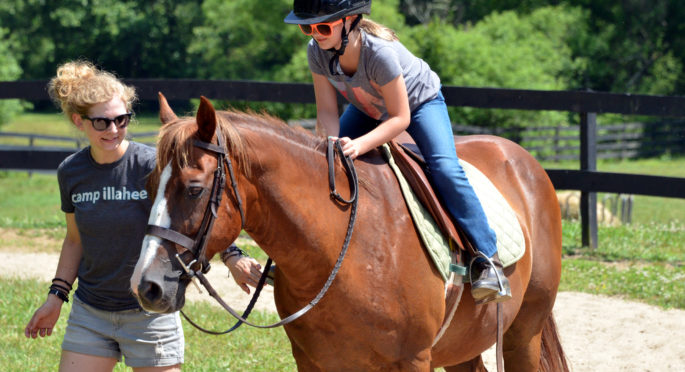 staff and camper on a sunny day at riding