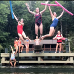 Synchronized Swimmers Begin their routine with a trio jumping off the diving board.