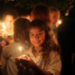 A Camper Holds a Wish Boat candle on the last night of camp.