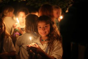 A Camper Holds a Wish Boat candle on the last night of camp.