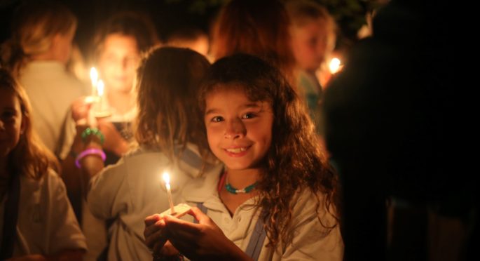 A Camper Holds a Wish Boat candle on the last night of camp.