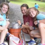 Two campers make homemade ice cream with their counselor.