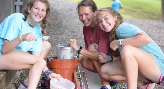 Two campers make homemade ice cream with their counselor.