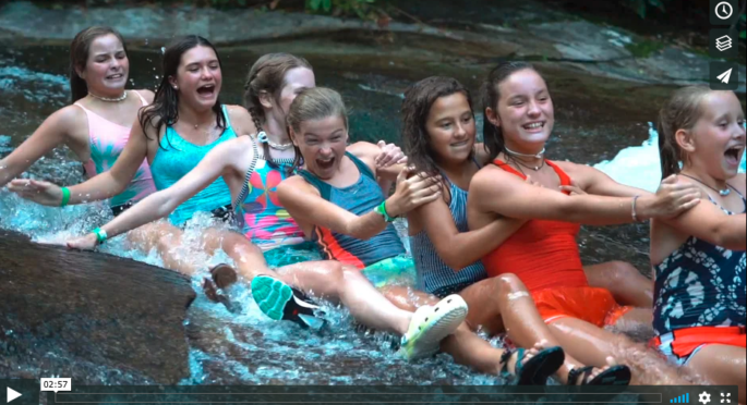 Campers from Camp Illahee heading down Sliding Rock in a train.